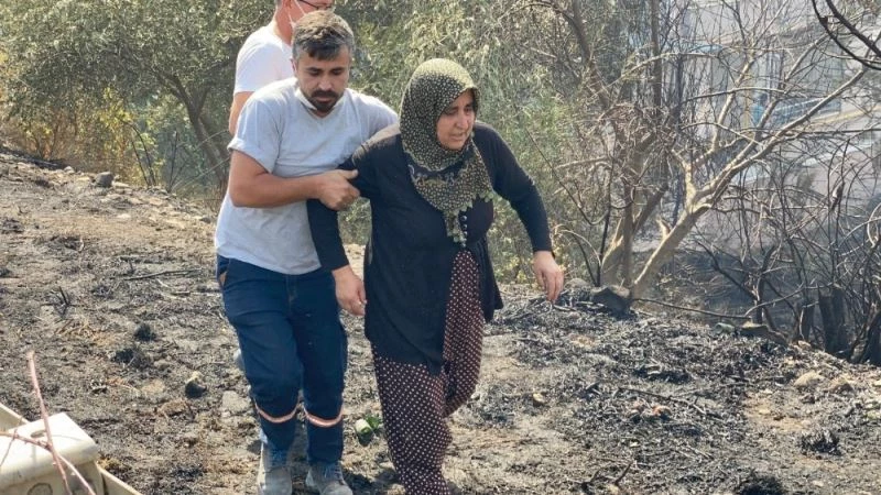 Yanan evine koşmaya çalışan kadını görevliler zor tuttu
