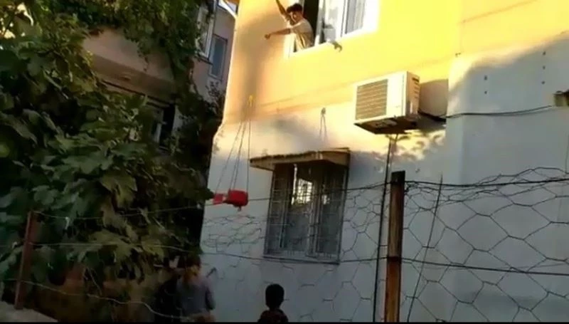 Karantinadaki genç doğum günü pastasını iple eve çekti
