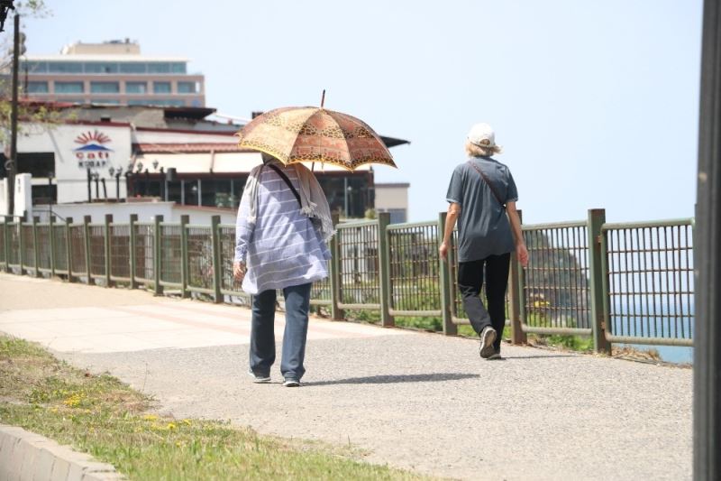 Sokağa çıkan yaşlılardan sıcağa karşı şemsiyeli önlem
