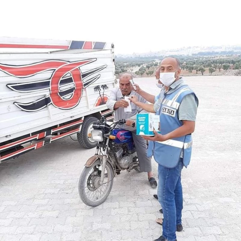 Hayvan pazarında gelenlerin ateşi ölçülüp maske veriliyor
