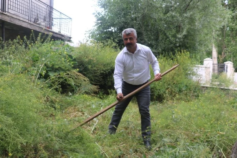 Çim biçme makinesi bozulunca belediye başkanı tırpanı eline aldı
