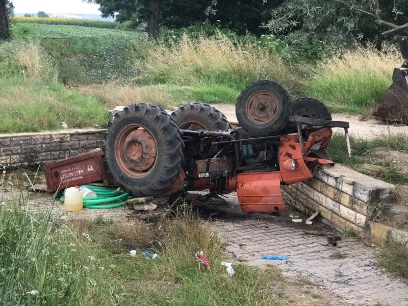 Devrilen traktörde az daha canından oluyordu
