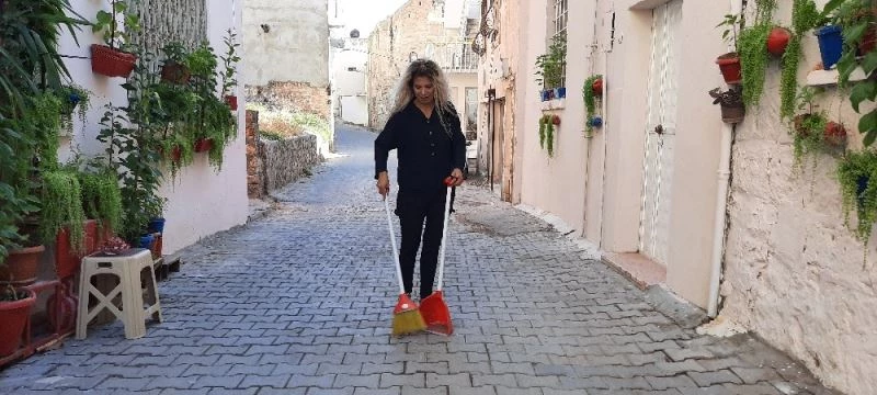 Doğadan topladığı bitkilerle süslediği sokağa bakan bir daha bakıyor
