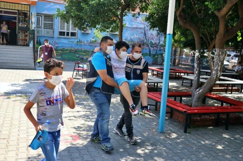 Ayağı kırık öğrenci polislerin kucağında sınava gireceği sınıfa götürüldü