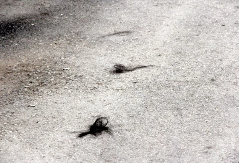 Darp edilen kadın saçlarını yoldan topladı
