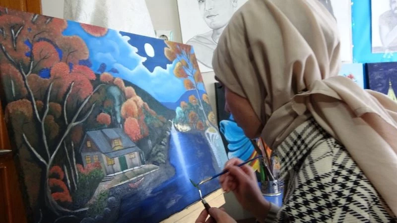 Evinin bir odasını atölyeye çeviren genç kız, hayallerini tuvallere yansıtıyor
