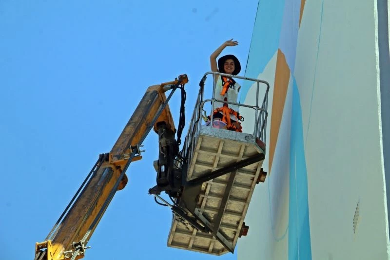 Kafasını kaldırıp vincin tepesinde elinde fırçayla görenler gözlerini alamıyor
