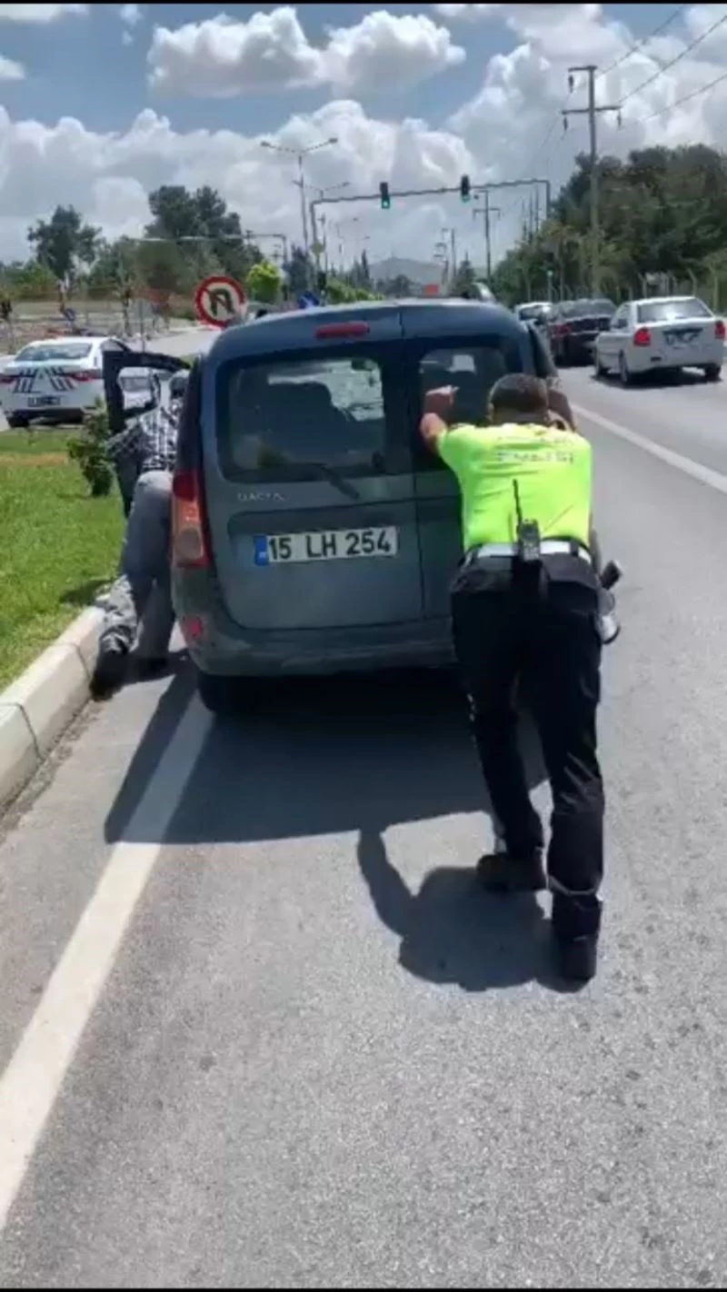 Trafik polisi, yolda kalan aracı iterek sürücüye yardım etti
