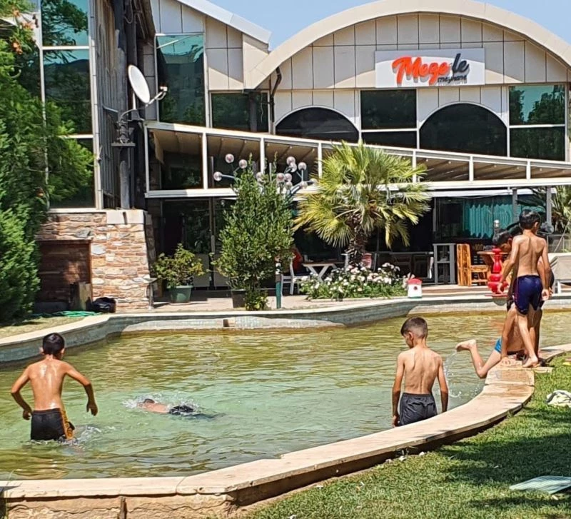 Denize ve paralı havuza gidemeyen çocuklar süs havuzlarında serinlemeye çalıştı
