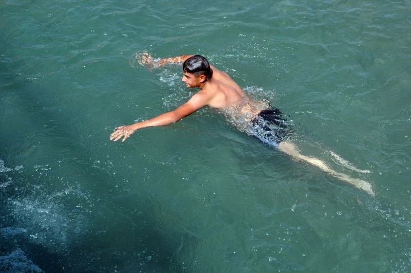 Aşırı sıcaklardan bunalan gençler derede serinliyor
