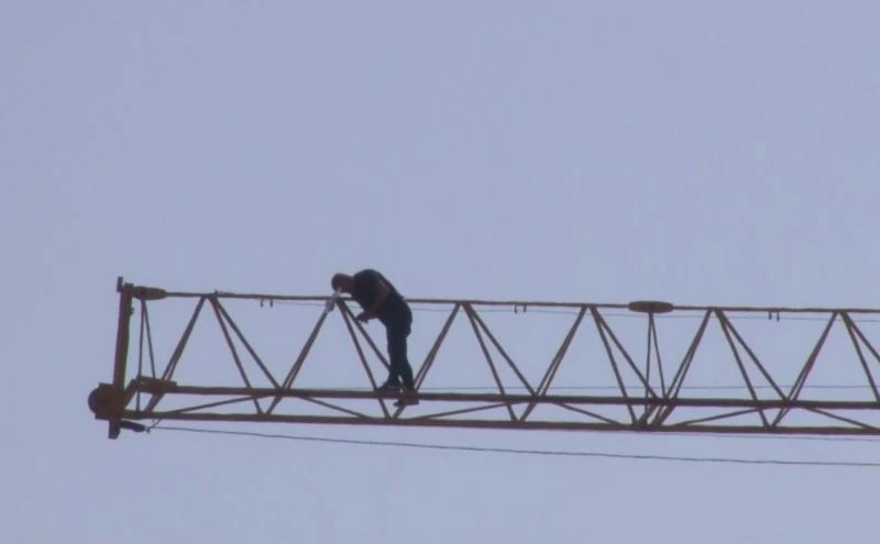 Parasını alamayınca vincin üzerine çıkıp intihara kalkıştı
