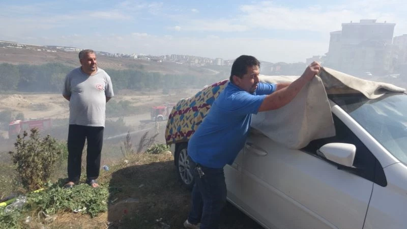 Yangına karşı ilginç yöntem: arabayı korumak için battaniyeyle kapladı
