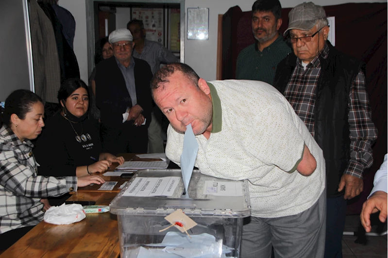 Kolları olmayan engelli seçmen, oy zarfını ağzıyla sandığa attı